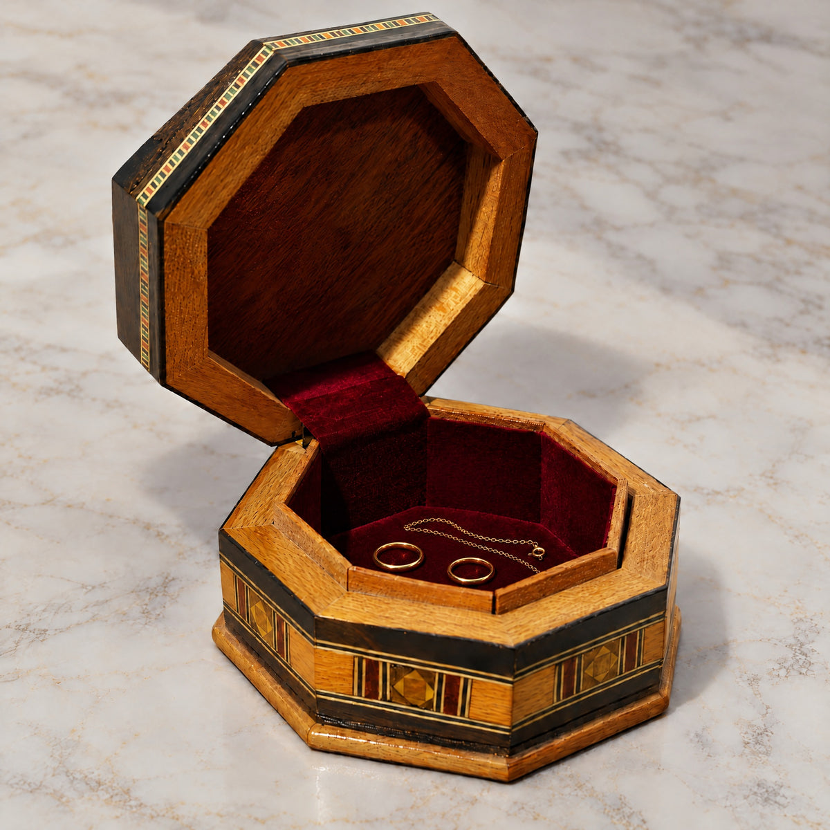 Olive Mosaic Box open on marble, velvet-lined interior with two rings