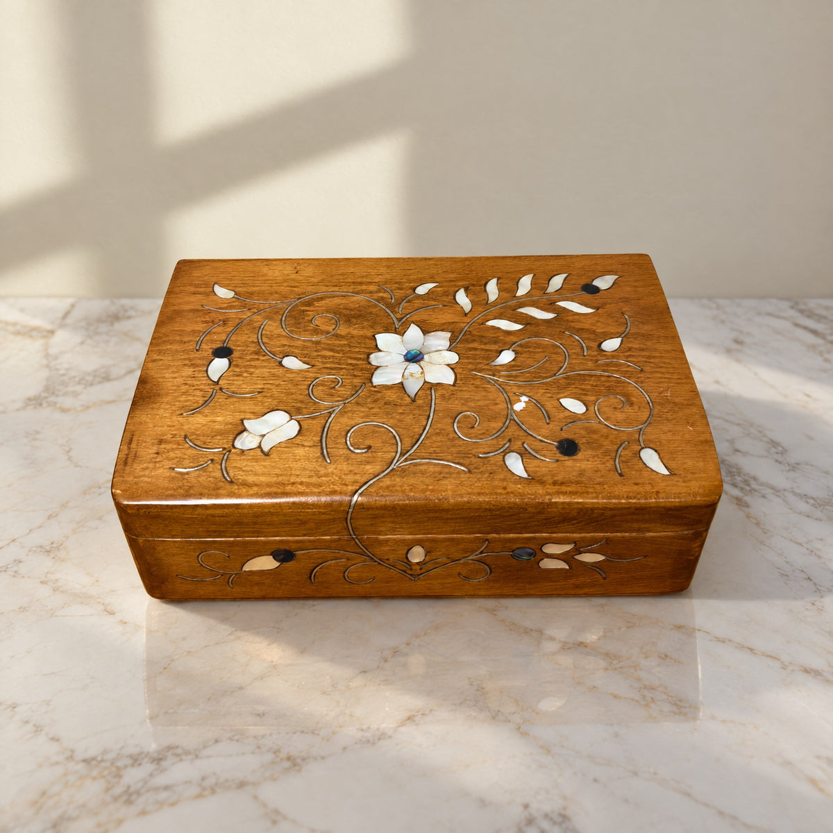 Arabesque Carved Box on a white marble table in warm window light