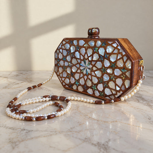 Najmeh Walnut Clutch on a white marble table in warm window light