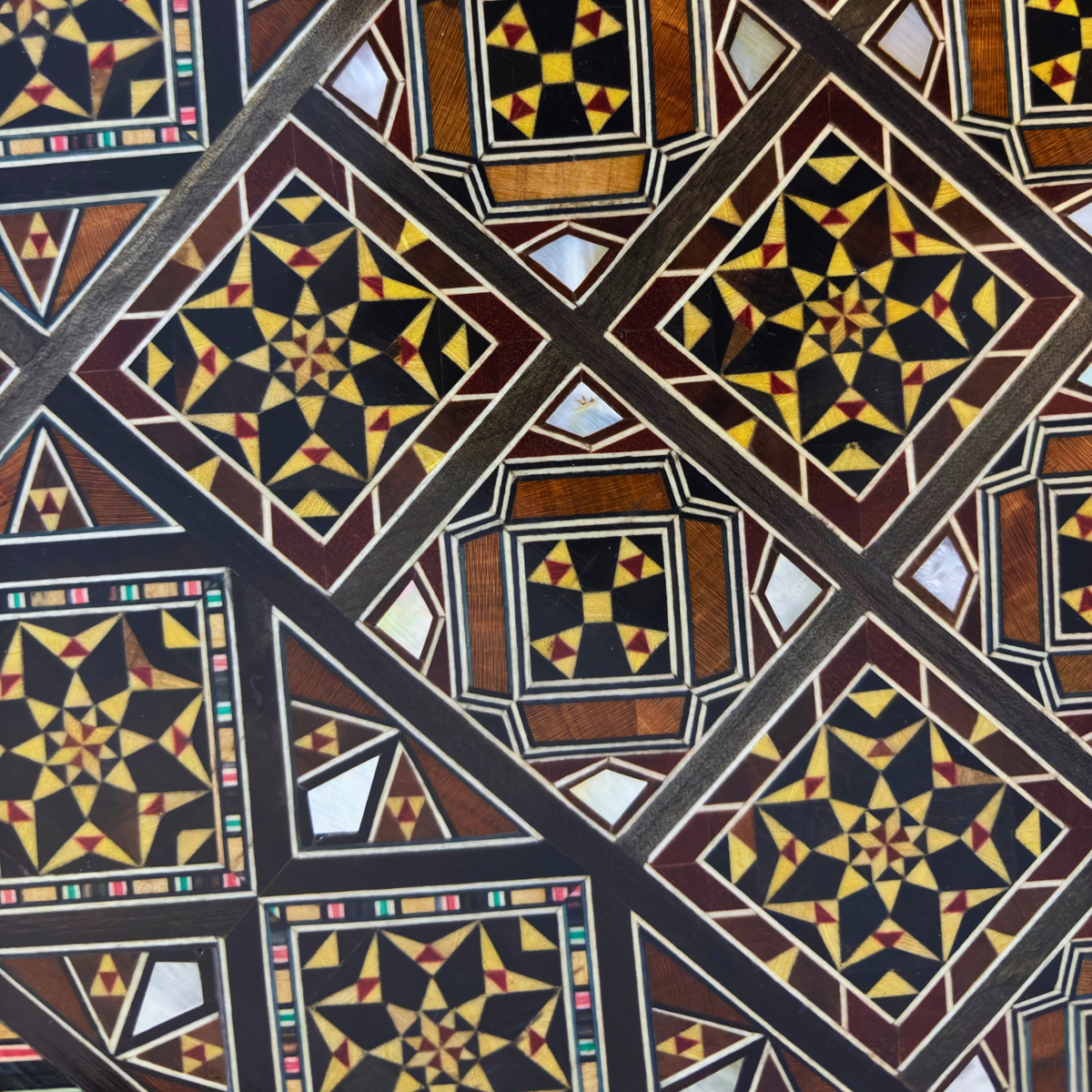 Pormenor do padrão geométrico em mosaico de madrepérola no tabuleiro do Conjunto Dinástico de Xadrez e Gamão