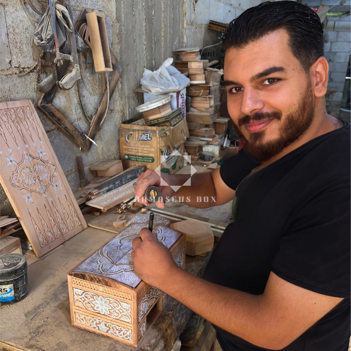 Mohammad Tarek Al-Dahh at work on a carved box in his workshop in Damascus