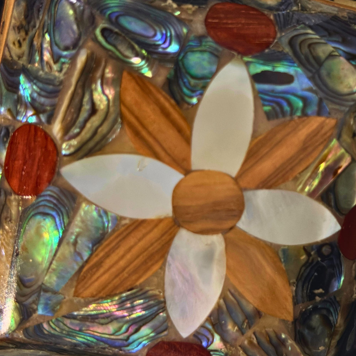 Close-up of the mother-of-pearl flower and green abalone shell on the lid