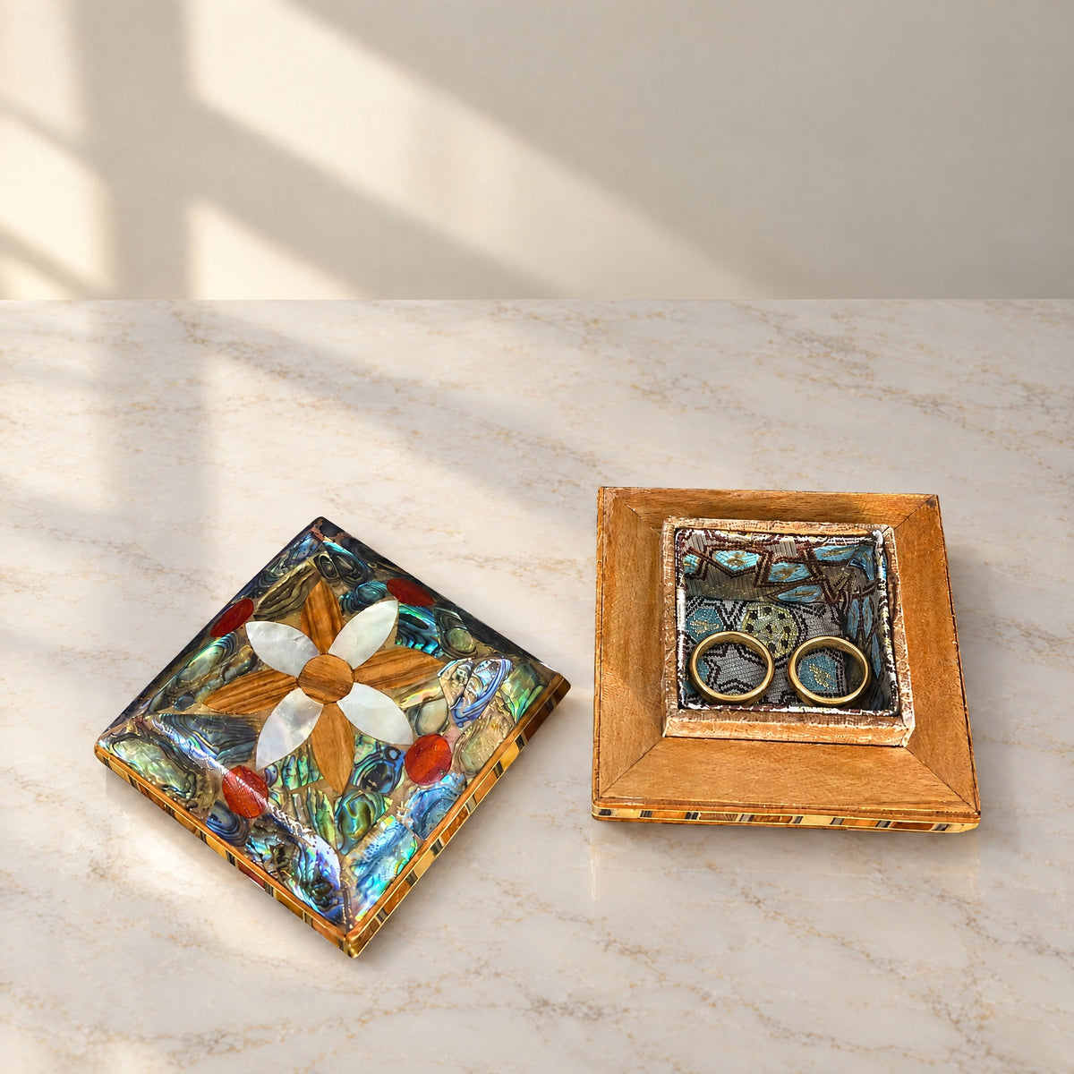 Treasure Mu'ashak box open on marble, showing the brocade-lined base with two rings beside its lid