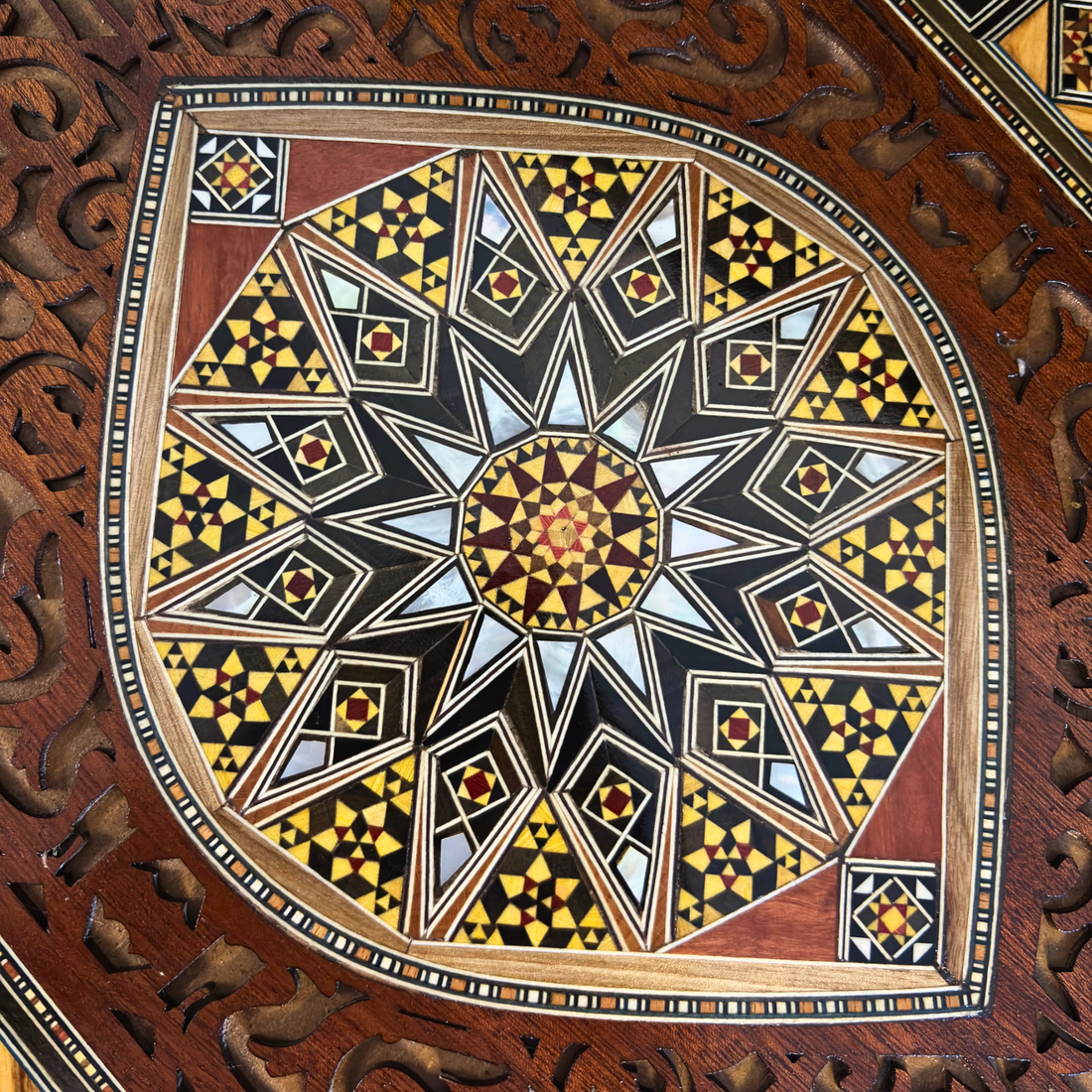 Close-up of a handcrafted Damascene mosaic tray, showing wood and mother-of-pearl inlay patterns