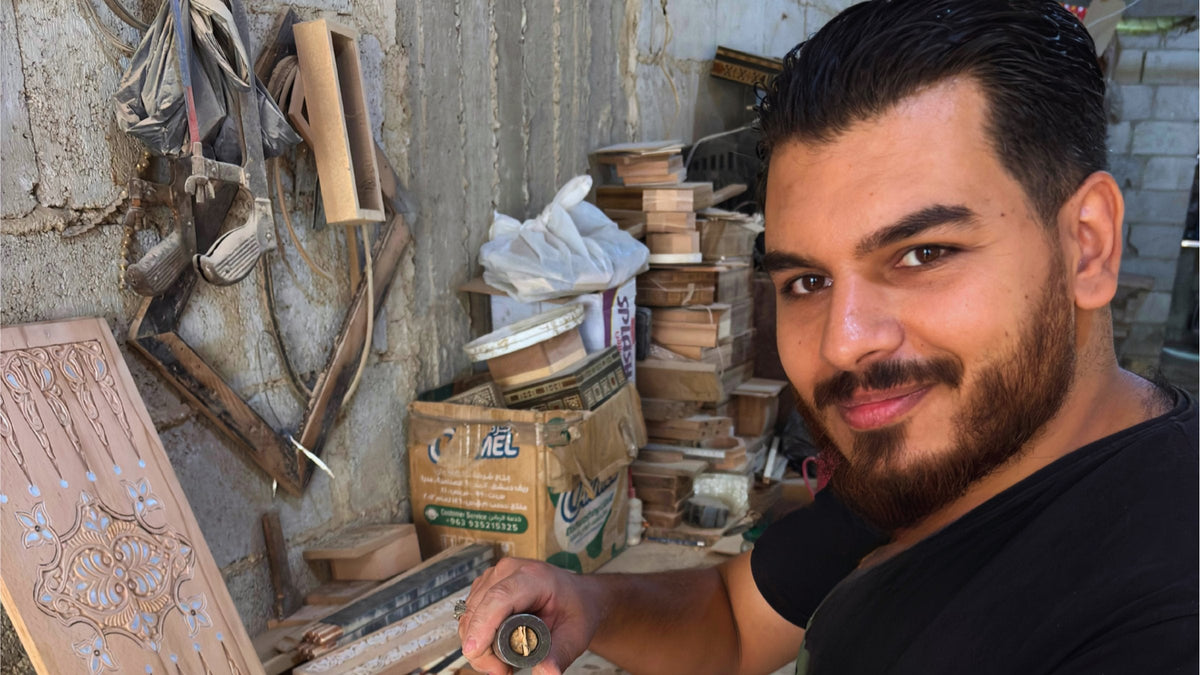 Mohammad Tarek Al-Dahh holding a mosaic box in his workshop in Damascus