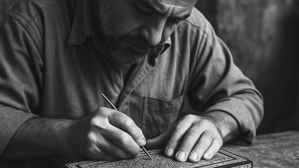 Black and white image of a craftsman working on an inlaid wooden box