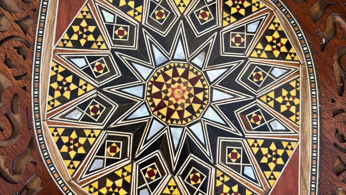 Close-up of a handcrafted Damascene mosaic tray, showing wood and mother-of-pearl inlay patterns