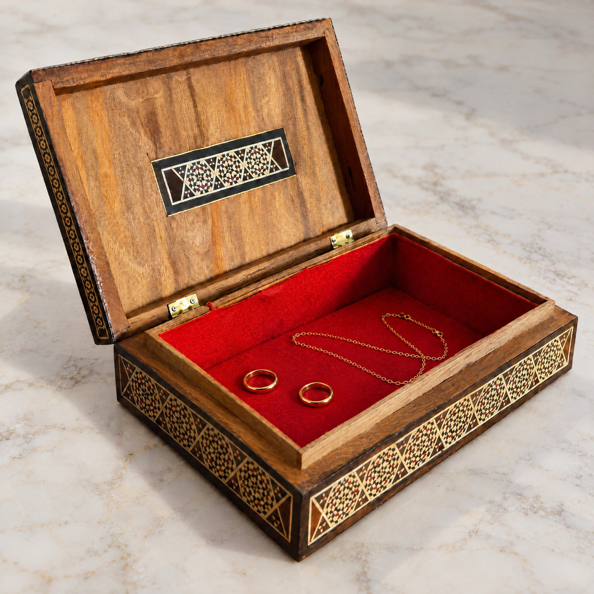 Caravan Mosaic Box open on marble, velvet-lined interior with two rings and a chain