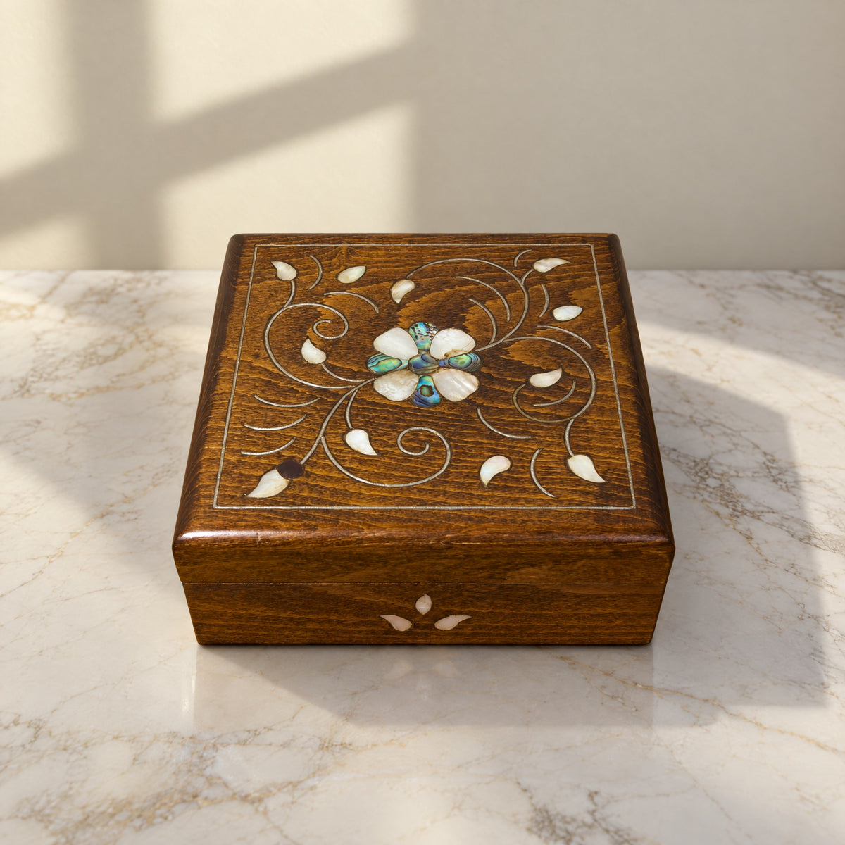 Mashghal Arabi Carved Box on a white marble table in warm window light