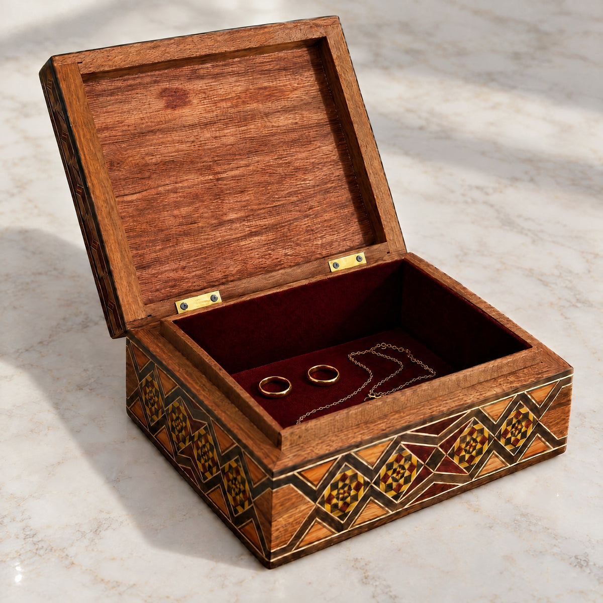 Storied Mosaic Box open on marble, velvet-lined interior with two rings and a chain