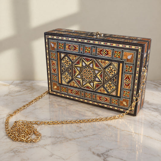 Layla Damascene Clutch on a white marble table in warm window light