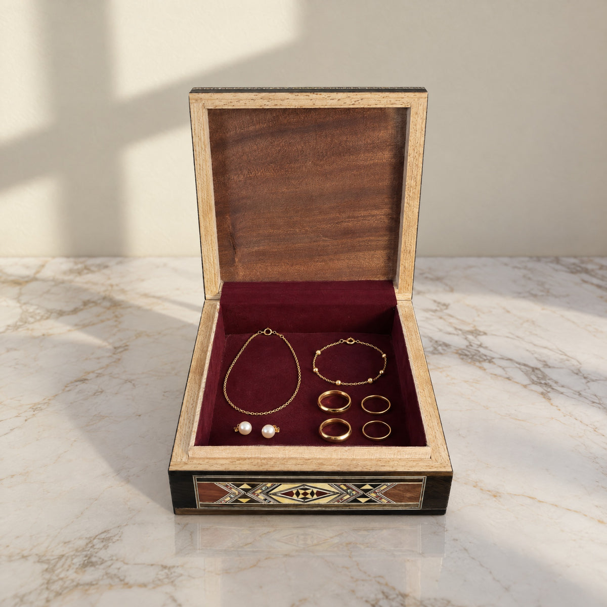 Tranquil Mosaic Box open, showing its wine-red velvet lining with a gold necklace, bracelet, rings and pearl earrings
