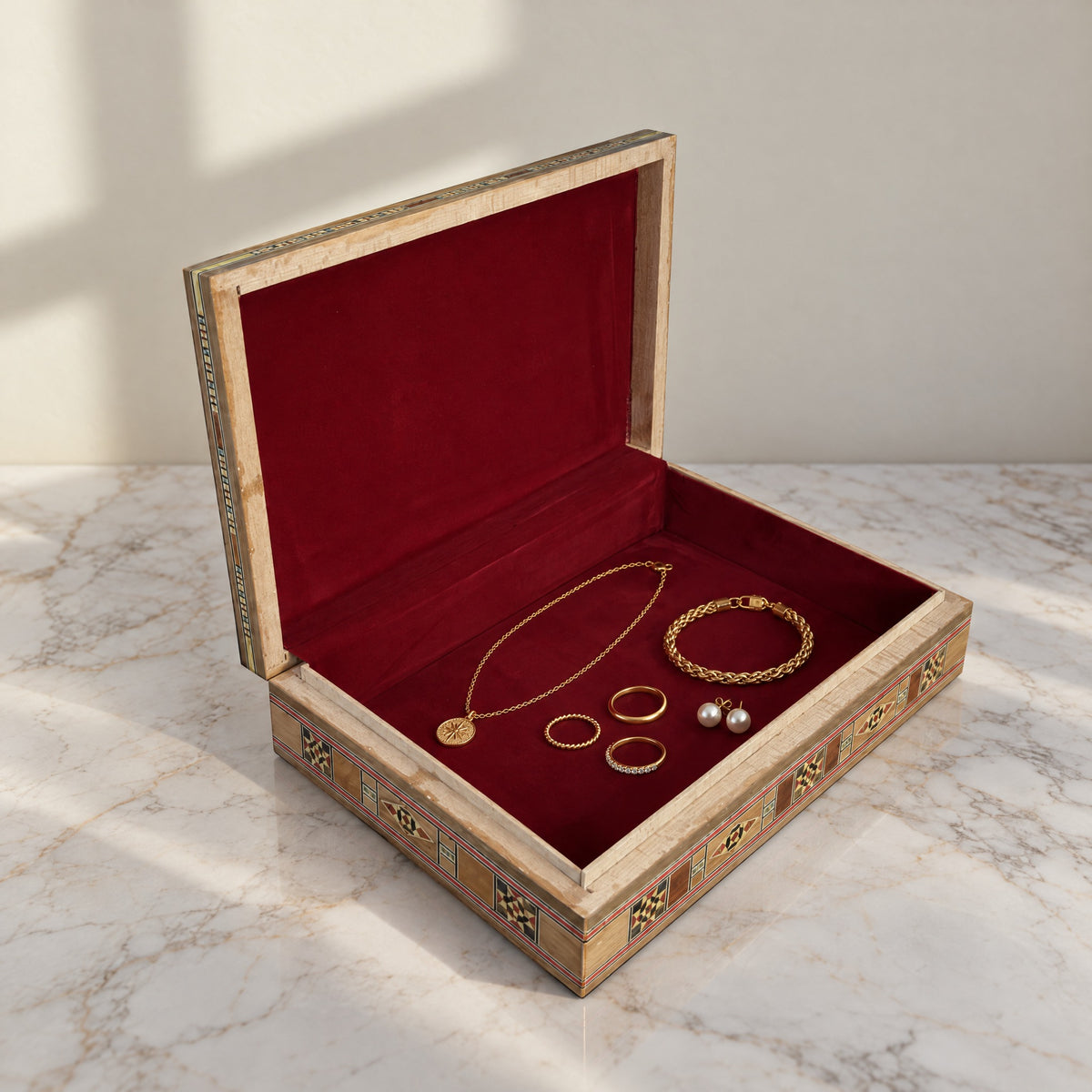 Stately Mosaic Box, open, showing its wine-red velvet lining with a gold necklace, bracelet, rings and pearl earrings