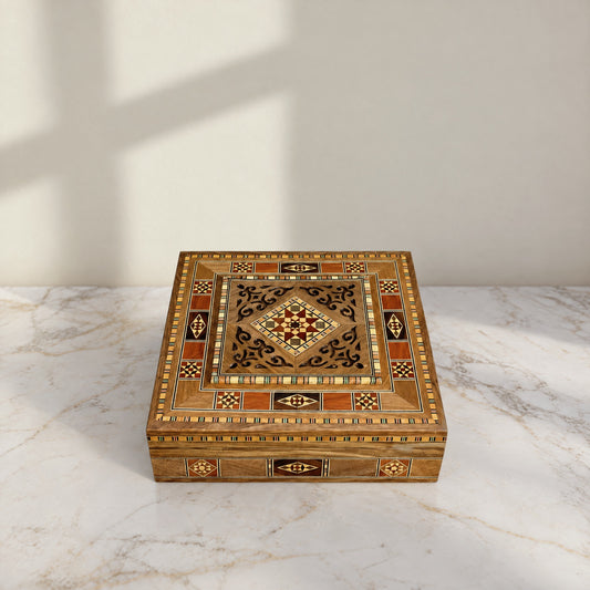 Graceful Mosaic Box, closed, on a white marble table in warm window light