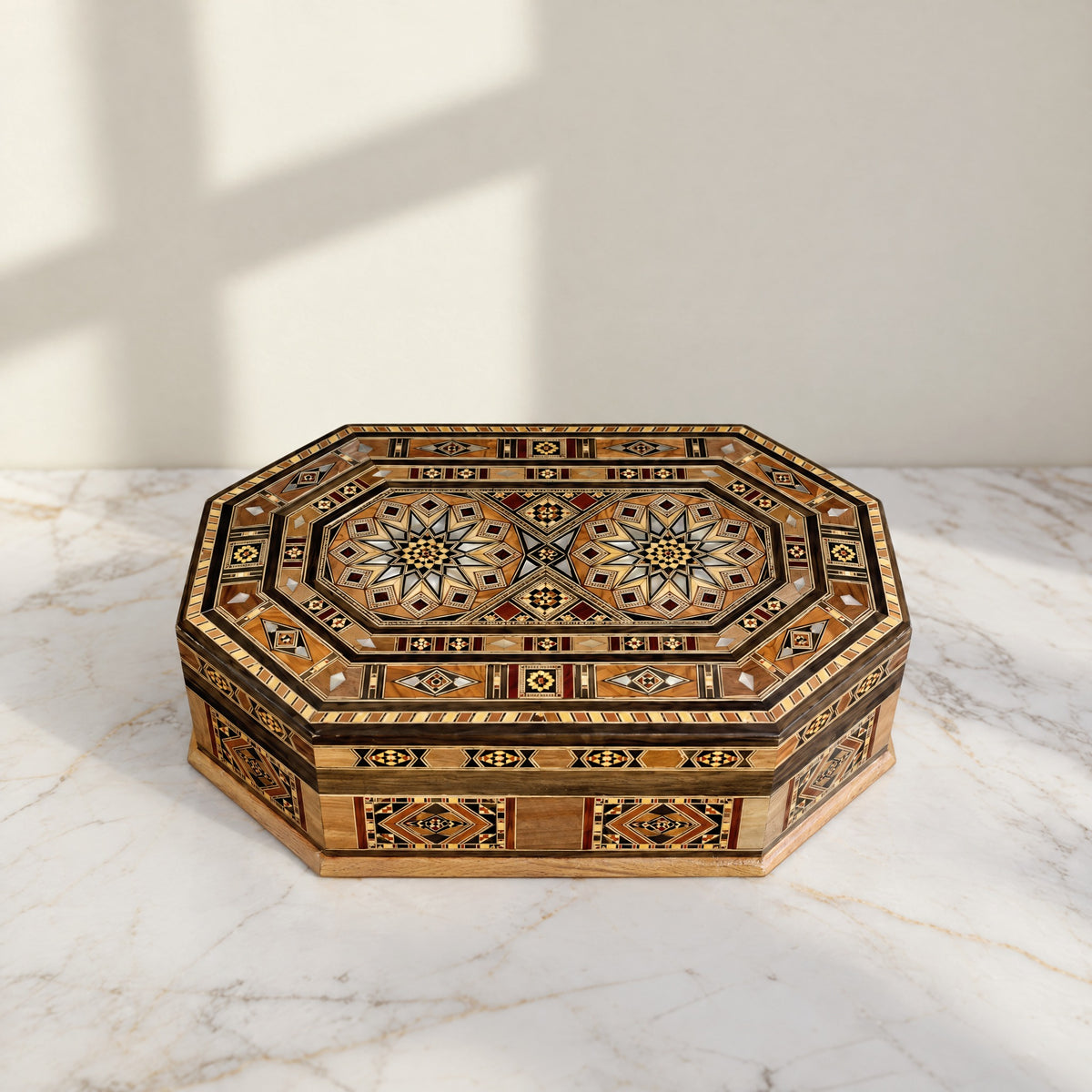 Resplendent Mosaic Box, closed, on a white marble table in warm window light