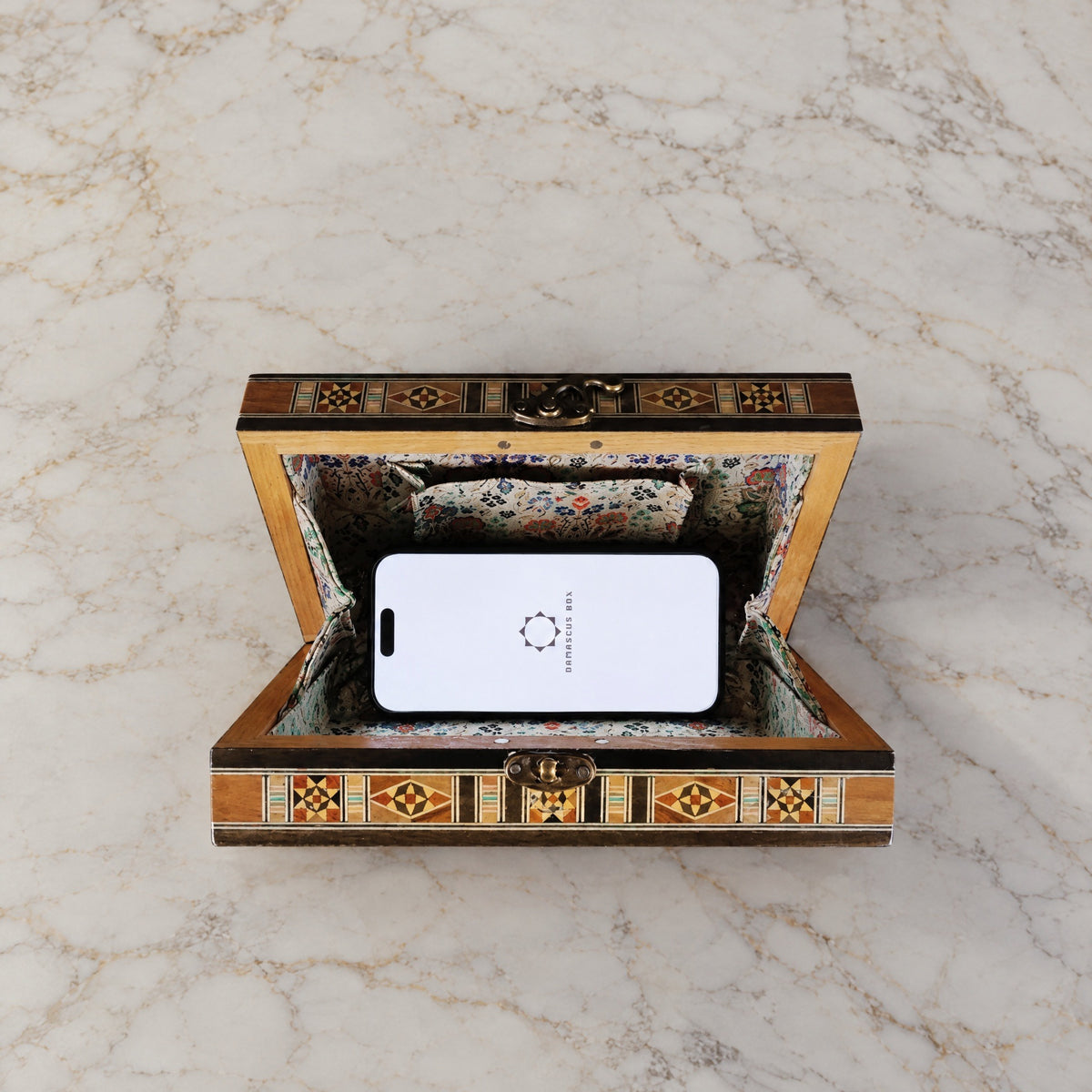 Layla Damascene Clutch open on marble with a smartphone inside